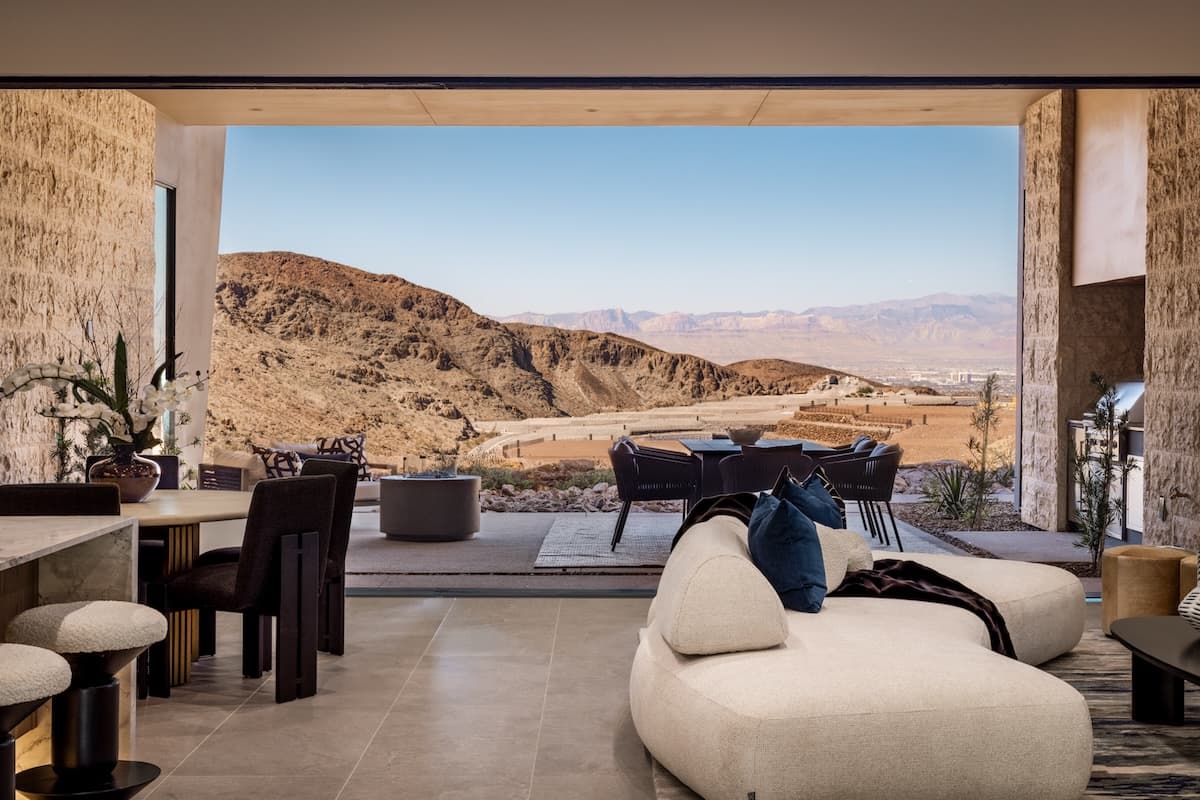Open-concept living space seamlessly connecting to a desert-view patio with lounge and dining areas.
