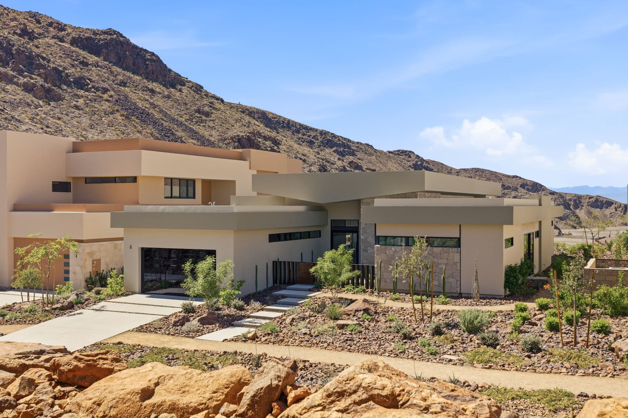 Modern luxury residence with contemporary architecture, open-concept living spaces, high-end finishes, expansive windows, and seamless indoor-outdoor design set against scenic desert mountain views.