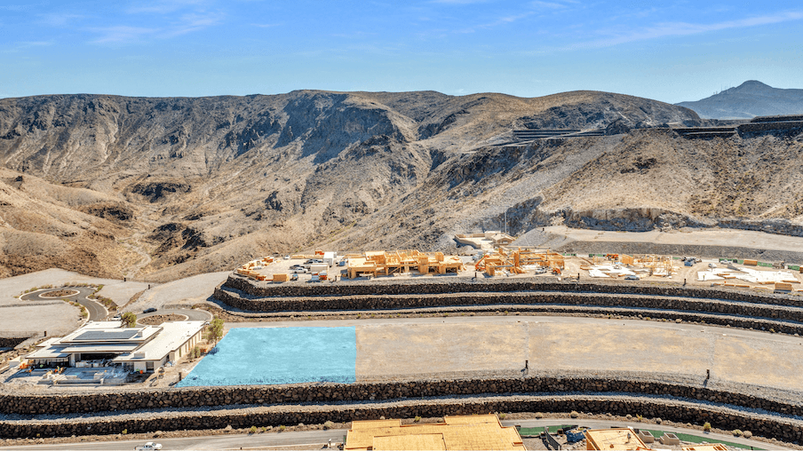 Aerial view of a modern hillside residential development in a desert landscape.