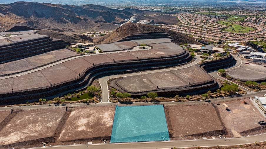 Aerial view of a modern hillside residential development in a desert landscape.