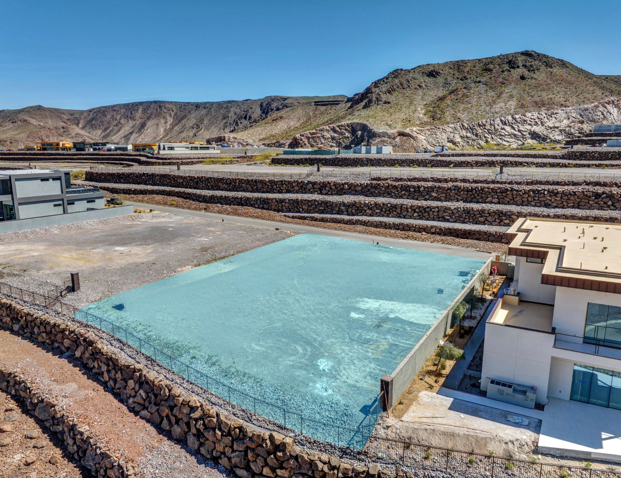 Aerial view of a modern hillside residential development in a desert landscape.