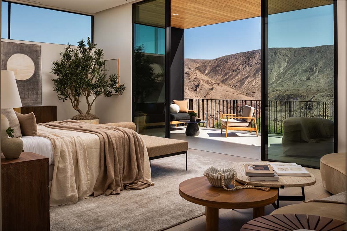 Modern luxury bedroom in Ascaya with floor-to-ceiling glass and desert mountain views