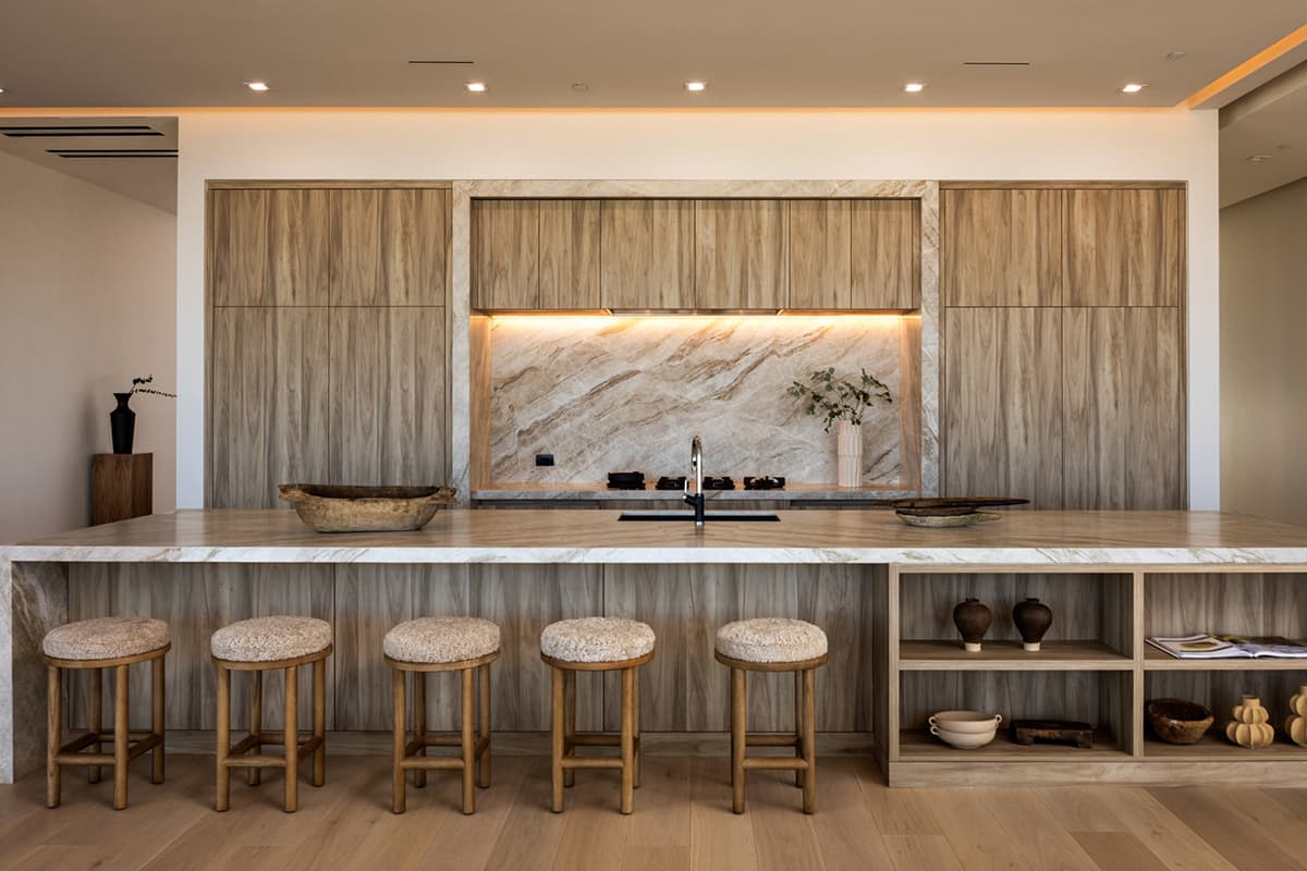 Minimalist luxury kitchen in Ascaya with natural stone finishes and custom wood cabinetry