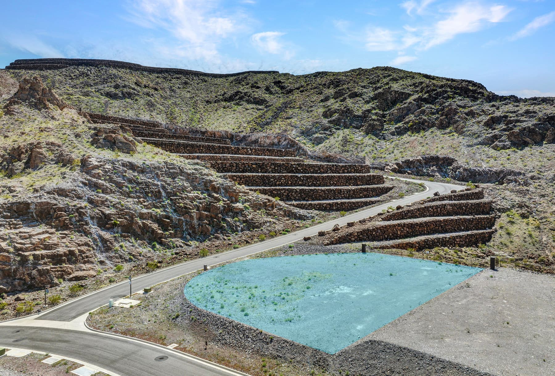 Aerial view of a modern hillside residential development in a desert landscape.