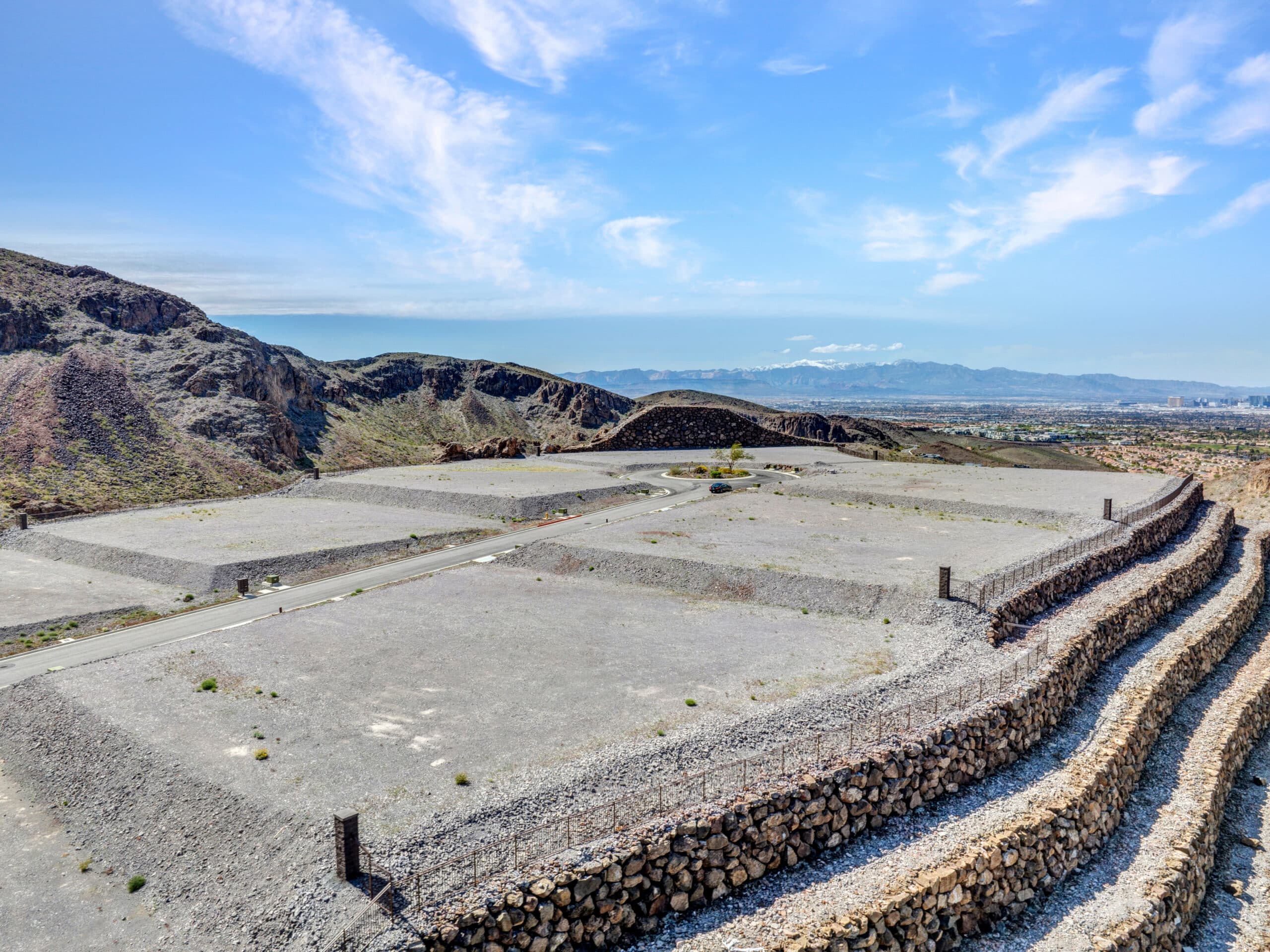Elevated custom homesite with terraced retaining walls and dramatic desert mountain views in a luxury Las Vegas residential community.