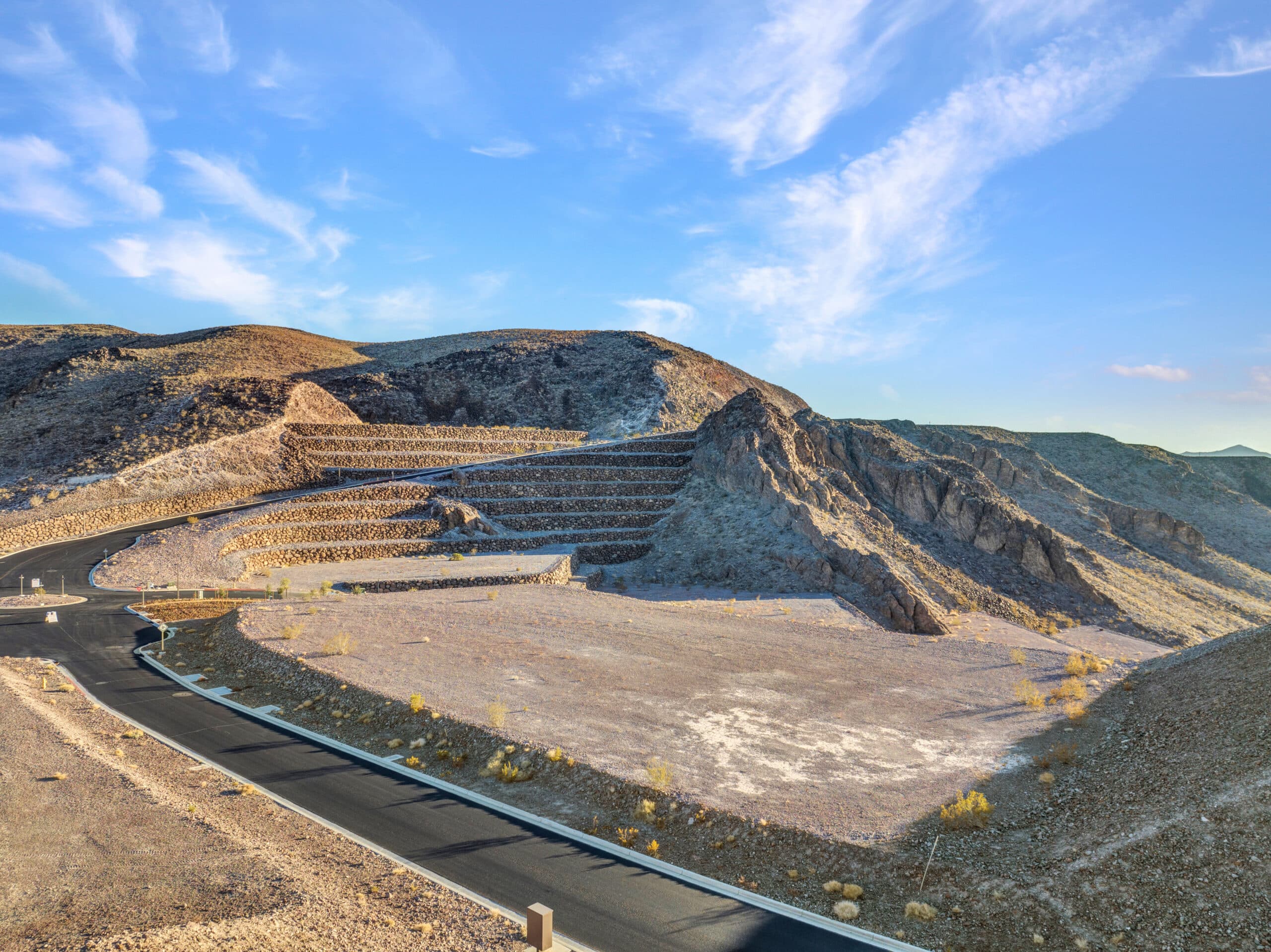 Expansive custom homesite with terraced retaining walls and scenic desert mountain views in a luxury Las Vegas hillside community.