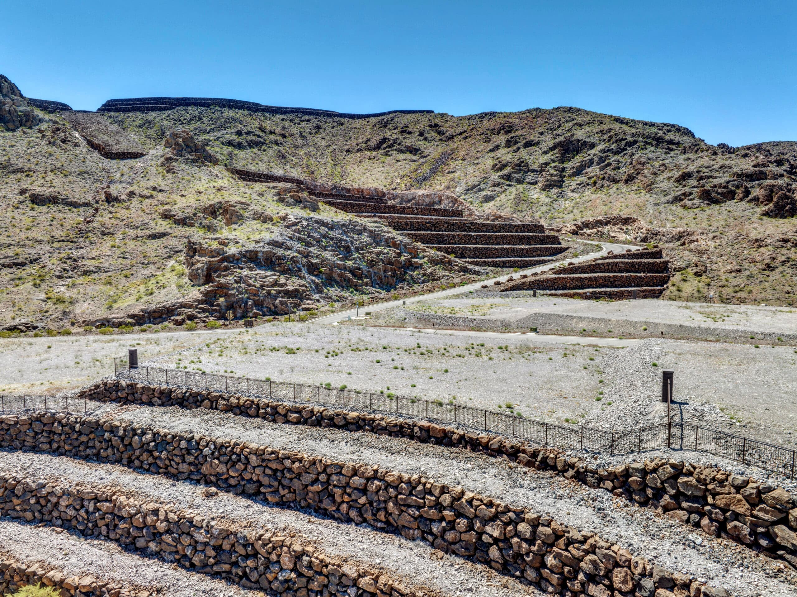 Elevated custom homesite with terraced retaining walls and dramatic desert mountain views in a luxury Las Vegas residential community.