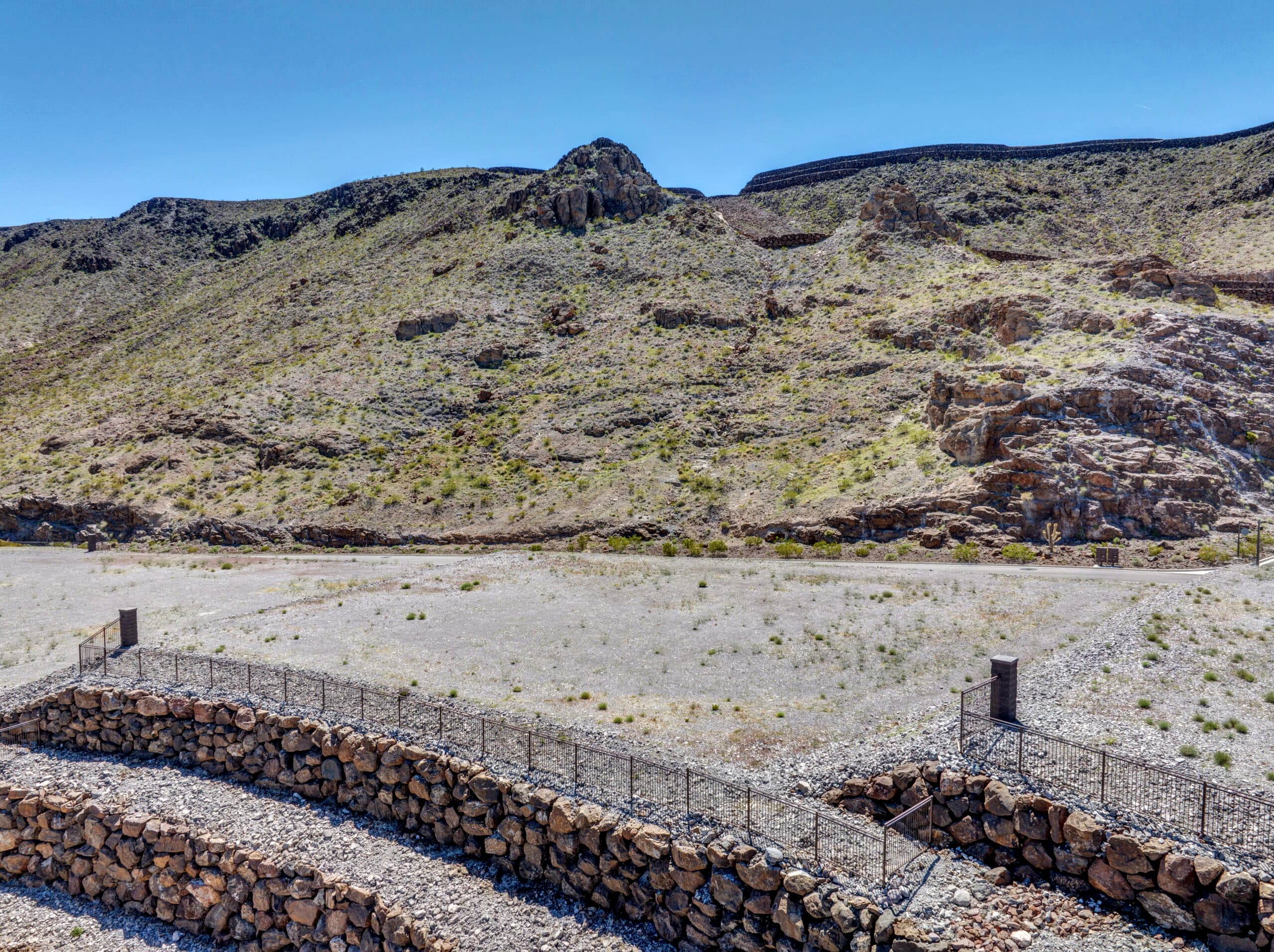 Elevated custom homesite with terraced retaining walls and dramatic desert mountain views in a luxury Las Vegas residential community.