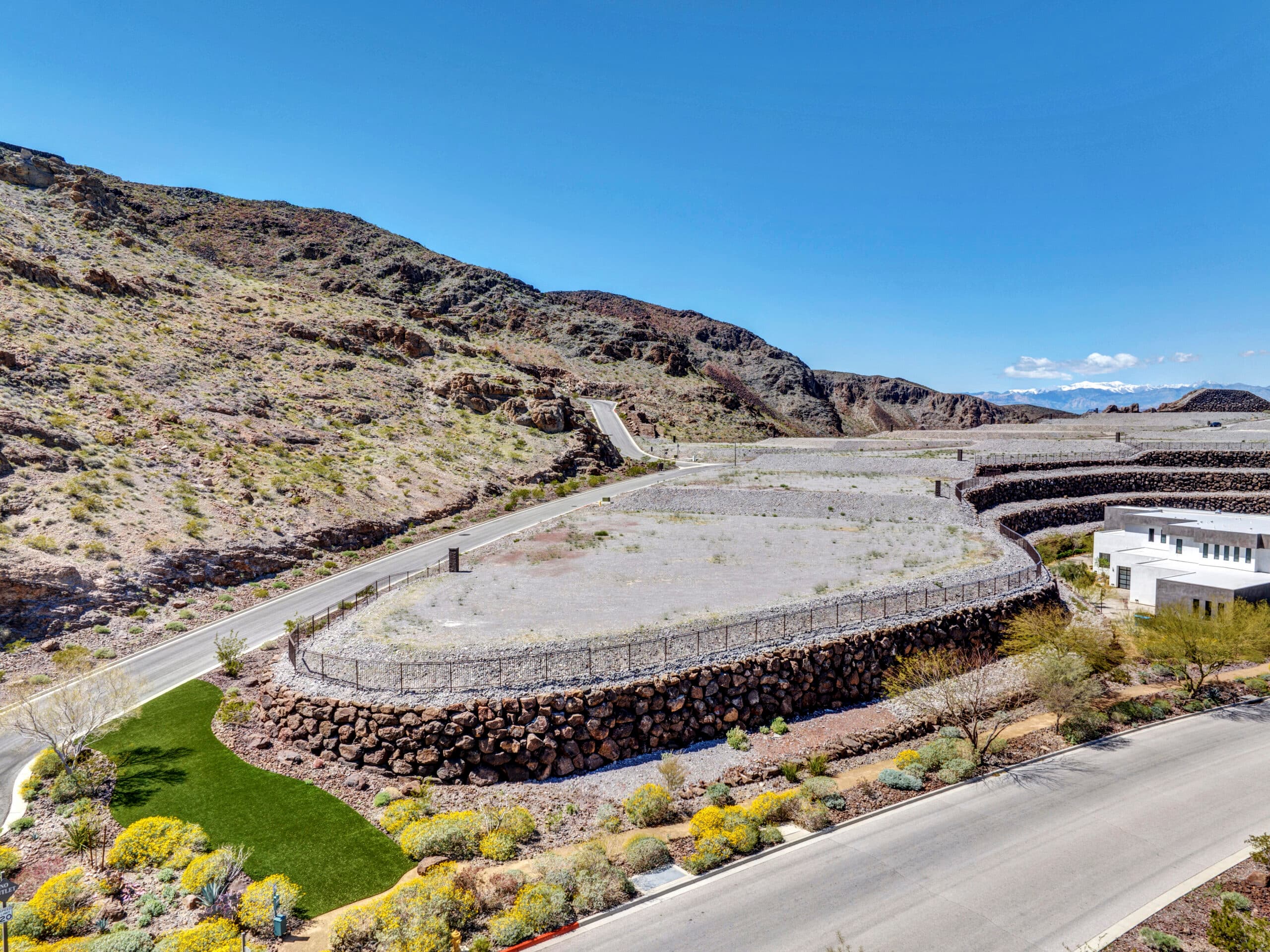 Elevated custom homesite with terraced retaining walls and dramatic desert mountain views in a luxury Las Vegas residential community.