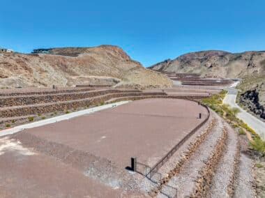 Aerial view of homesite lot outlined within a desert mountainside community development