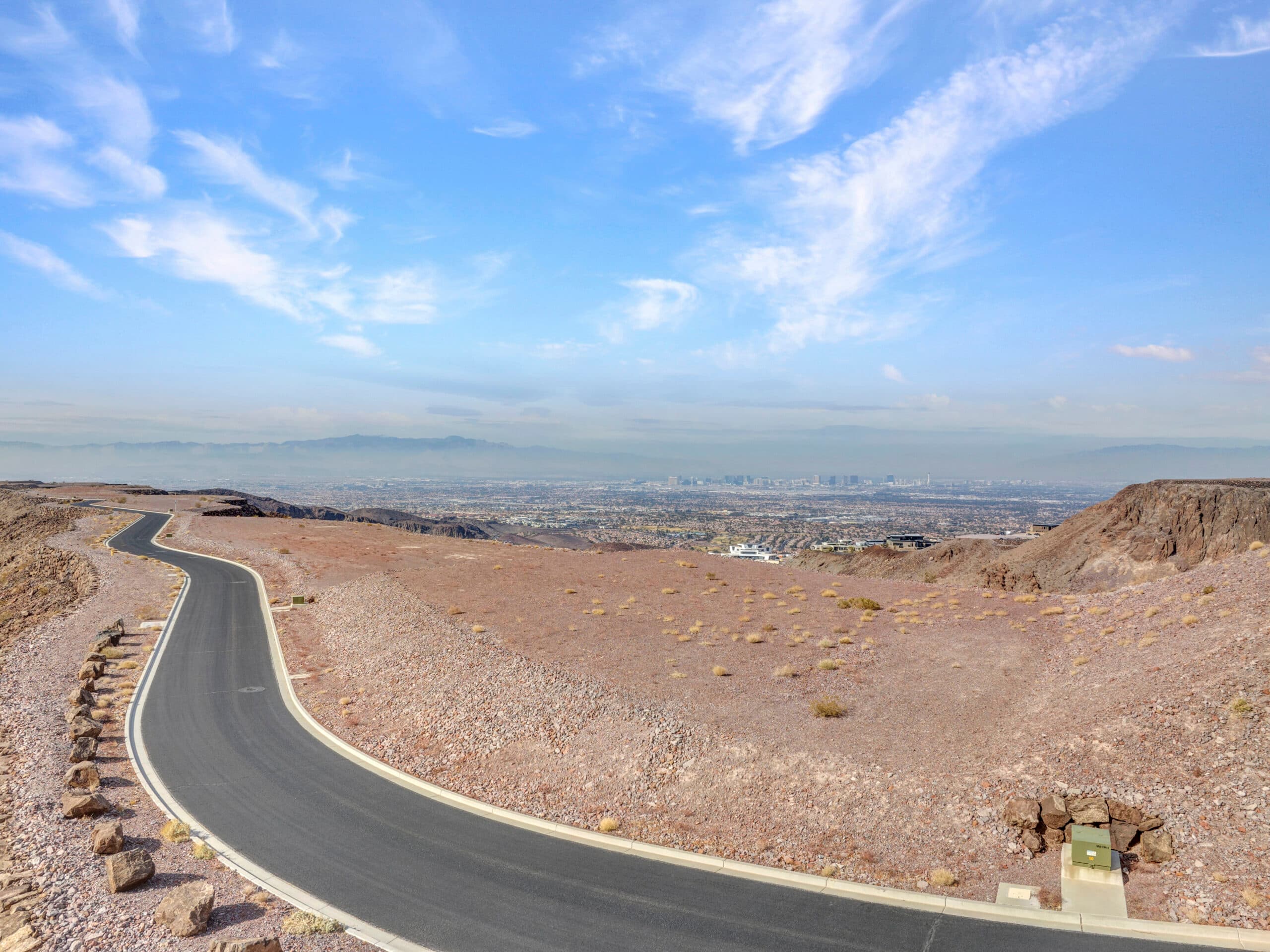 Expansive desert homesite with panoramic Las Vegas Strip and mountain views in luxury hillside community.
