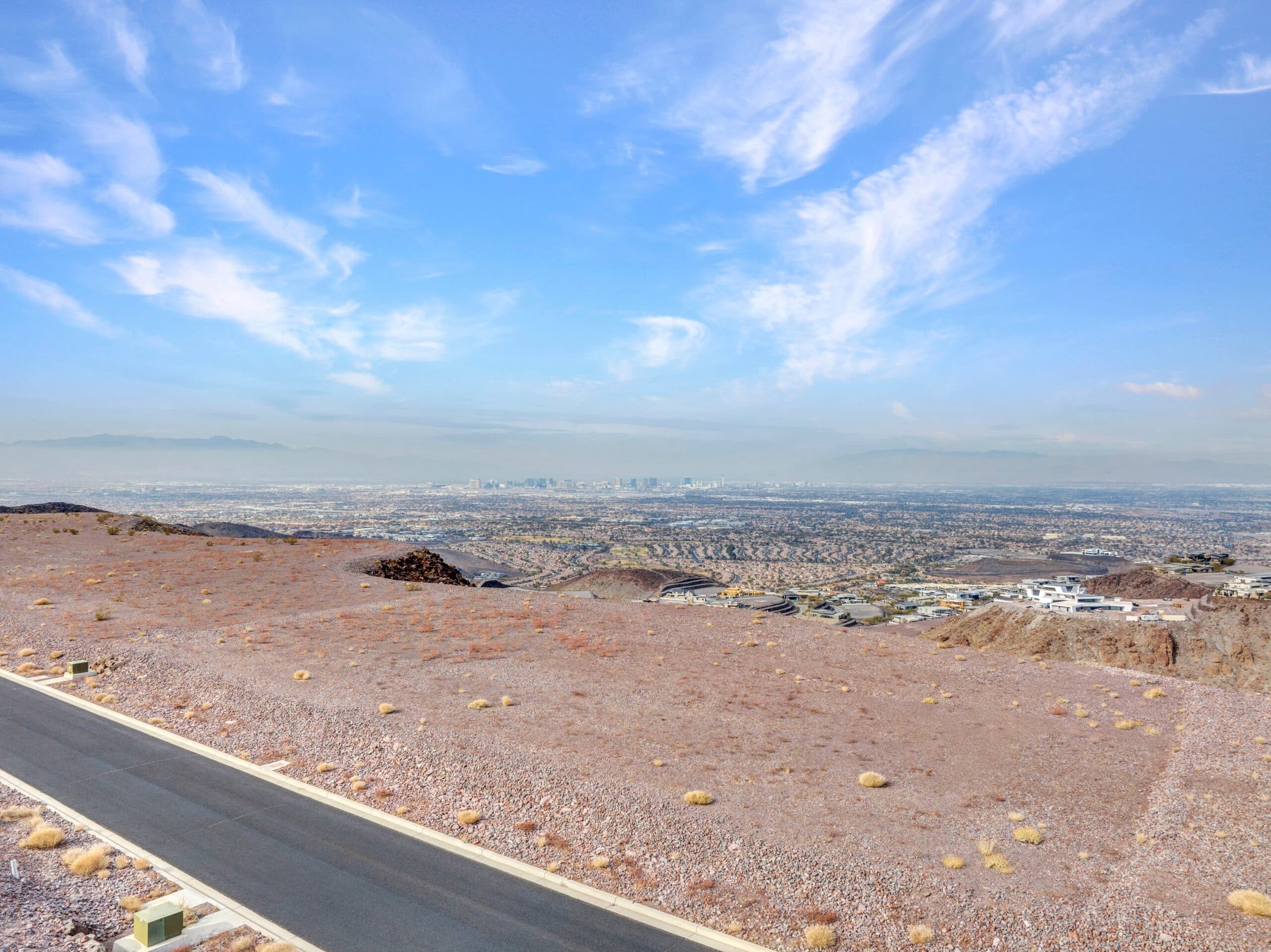 Expansive desert homesite with panoramic Las Vegas Strip and mountain views in luxury hillside community.