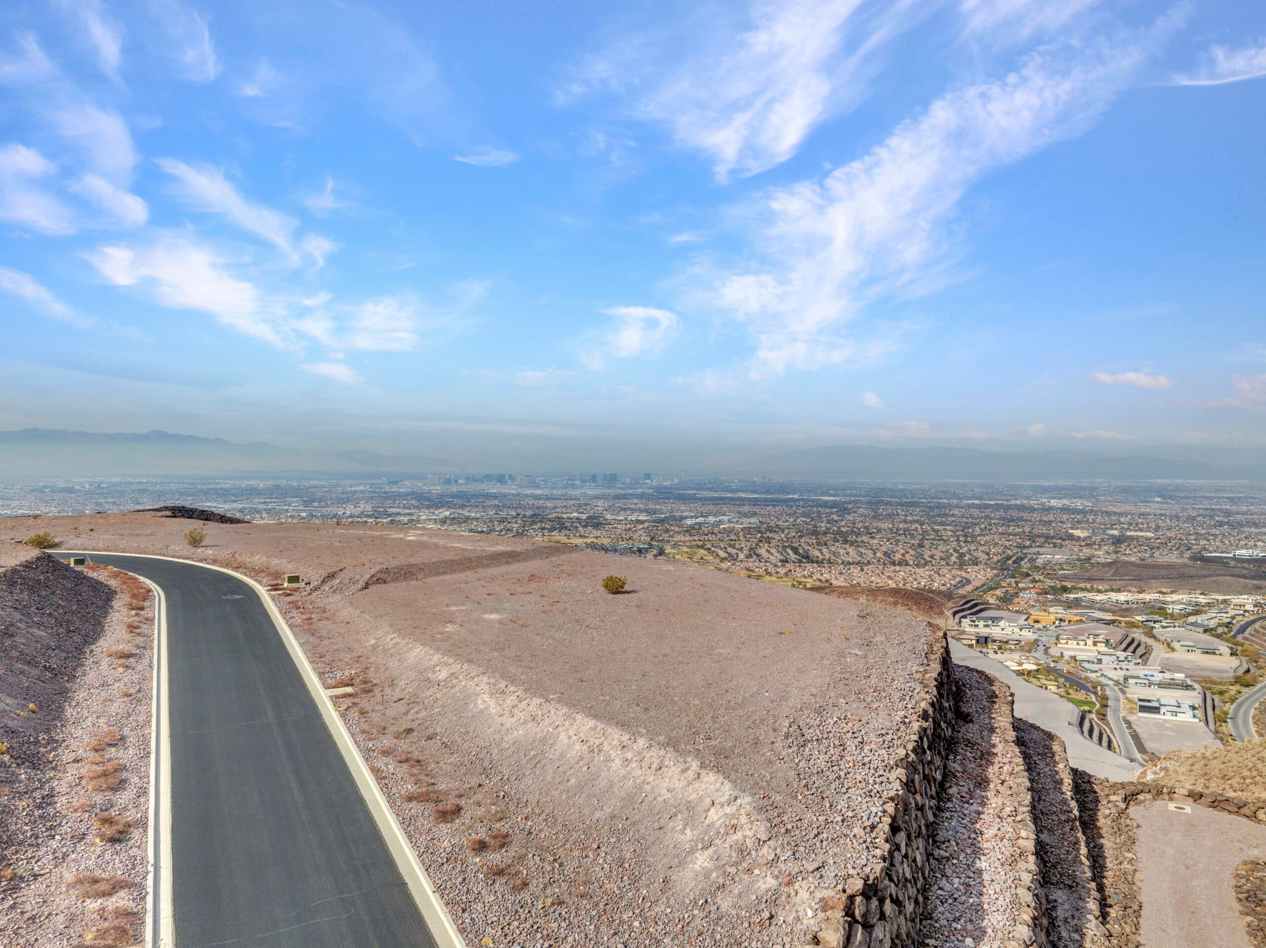 Expansive desert homesite with panoramic Las Vegas Strip and mountain views in luxury hillside community.