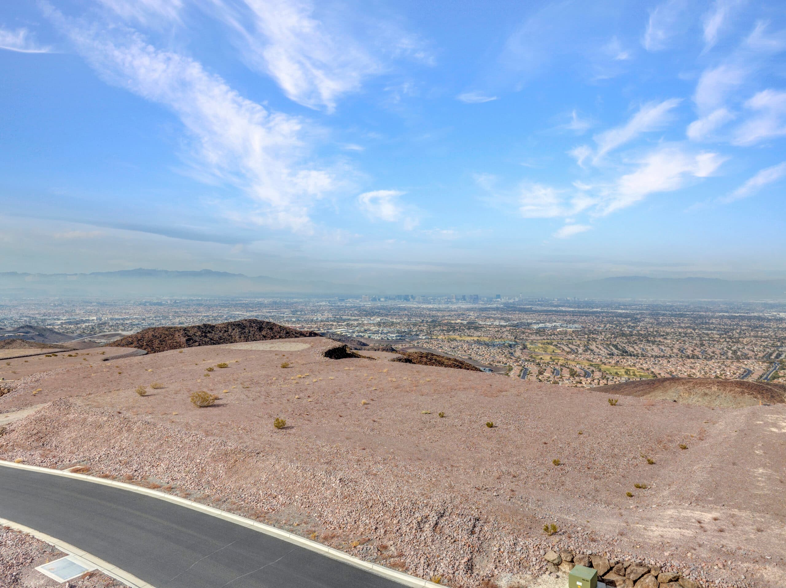 Expansive desert homesite with panoramic Las Vegas Strip and mountain views in luxury hillside community.
