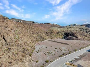 Aerial view of homesite lot outlined within a desert mountainside community development