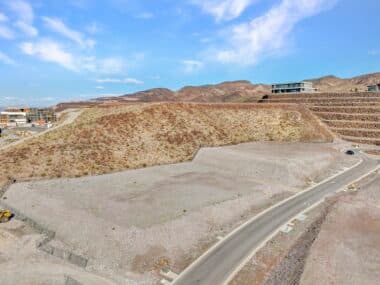 Aerial view of homesite lot outlined within a desert mountainside community development
