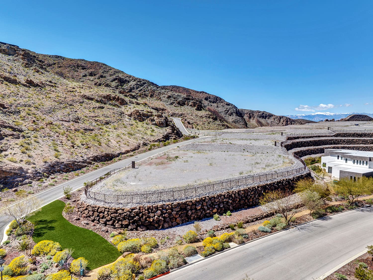 Elevated custom homesite with terraced retaining walls and dramatic desert mountain views in a luxury Las Vegas residential community.