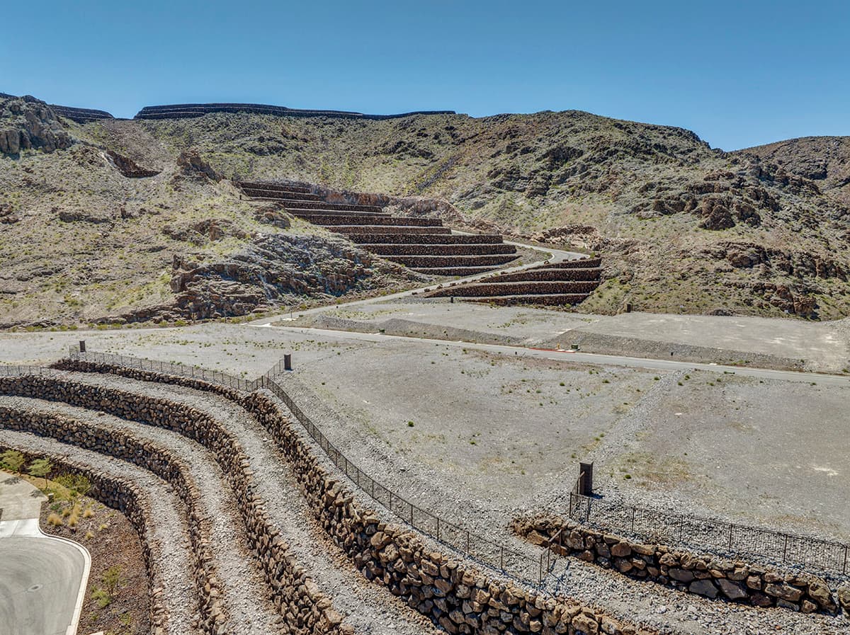 Elevated custom homesite with terraced retaining walls and dramatic desert mountain views in a luxury Las Vegas residential community.