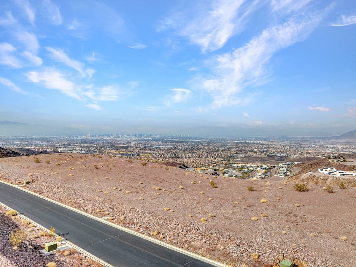 Expansive desert homesite with panoramic Las Vegas Strip and mountain views in luxury hillside community.