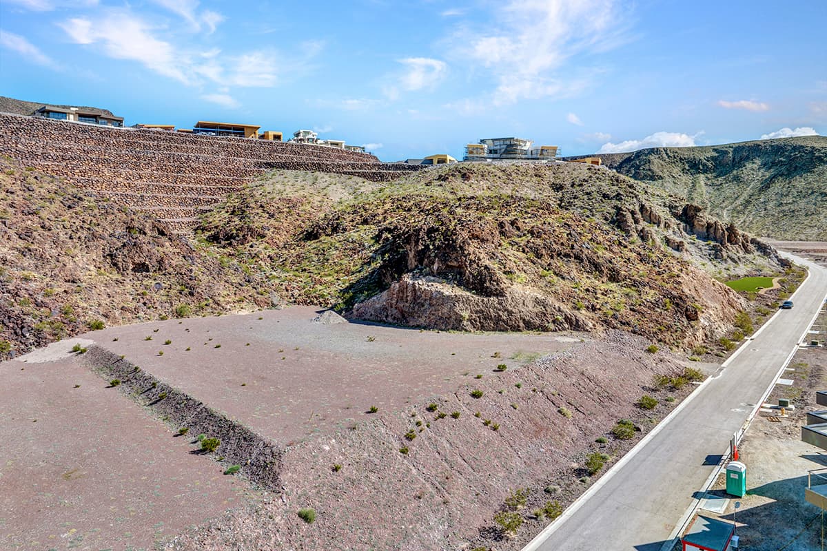 Aerial view of Homesite 57 at 26 Rockstream Drive, a terraced desert homesite set below rugged rock formations and contemporary Ascaya residences.