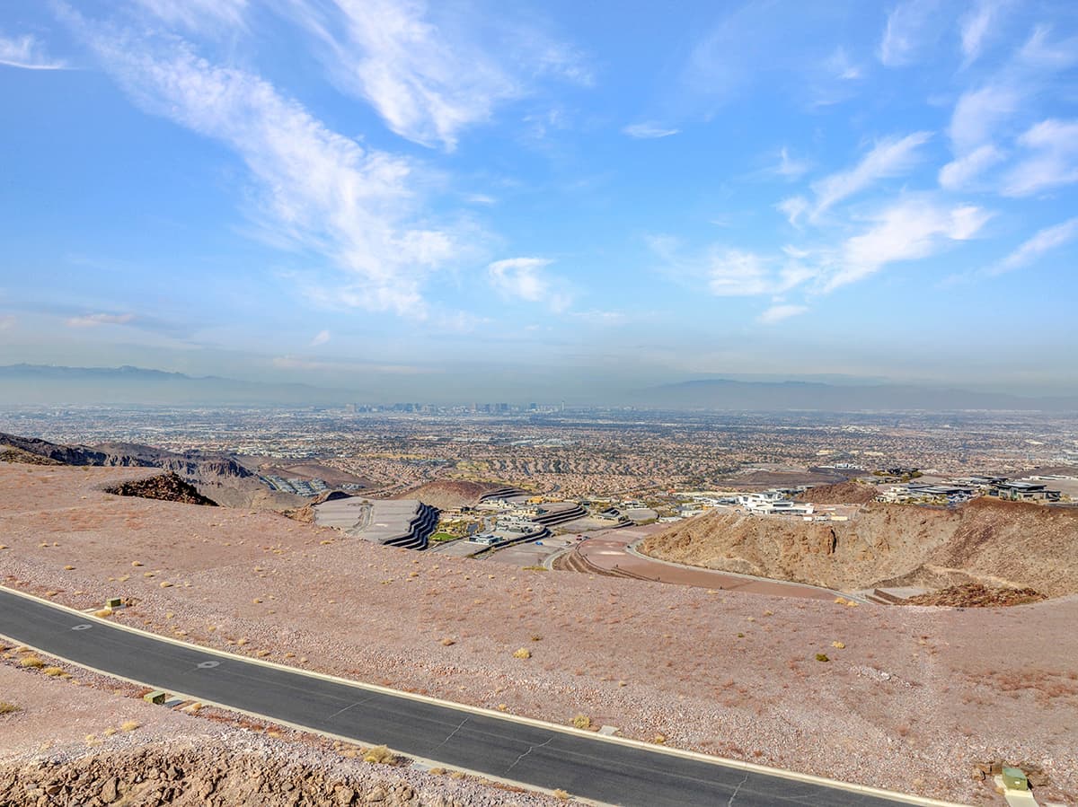 Expansive desert homesite with panoramic Las Vegas Strip and mountain views in luxury hillside community.