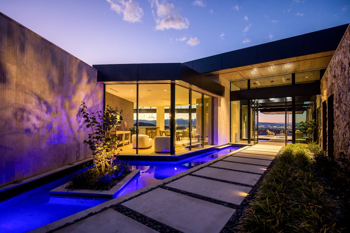 Modern desert home exterior at dusk with ambient lighting.