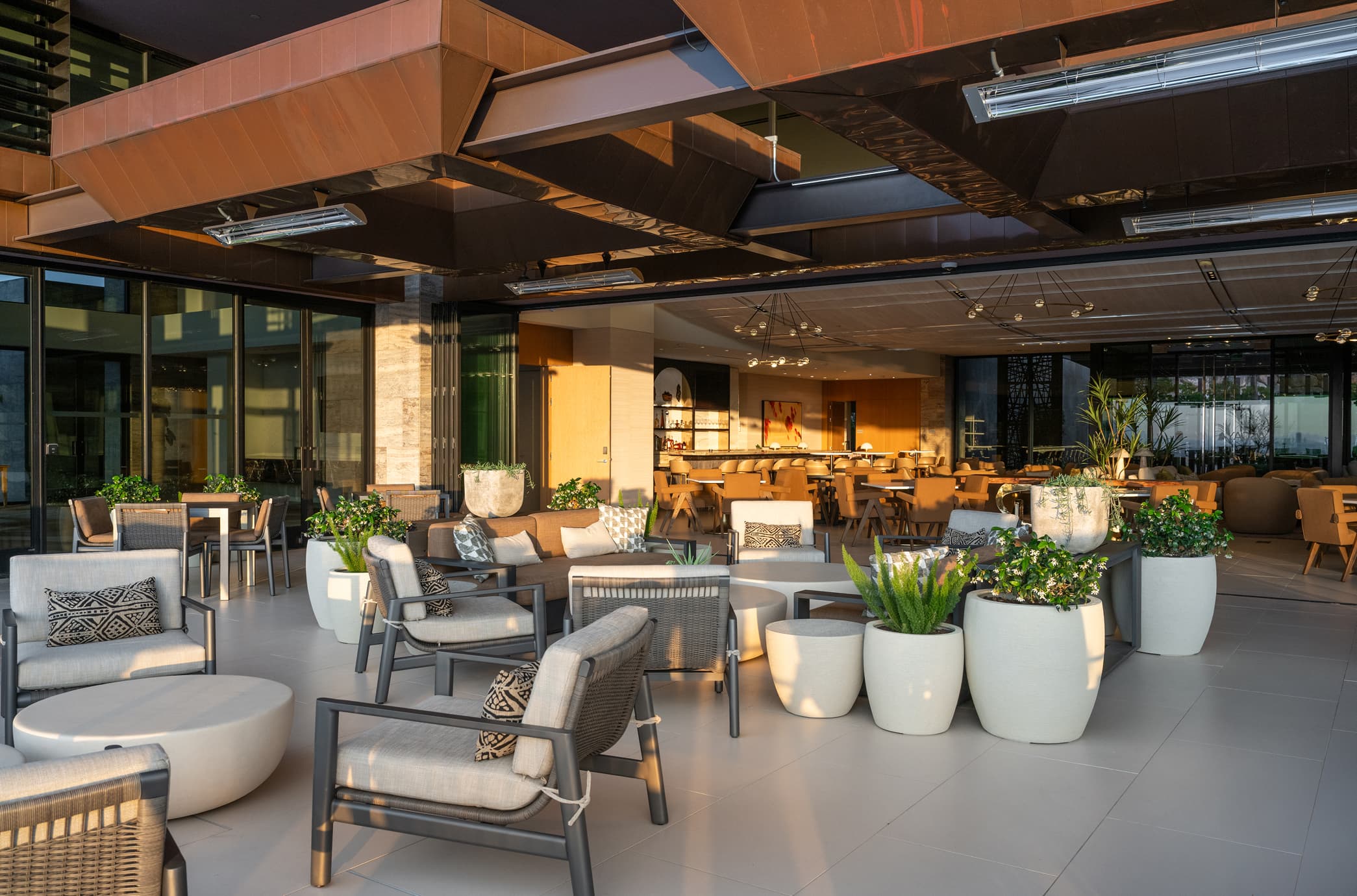 Luxury outdoor clubhouse lounge with modern seating, covered patio, and upscale dining area.