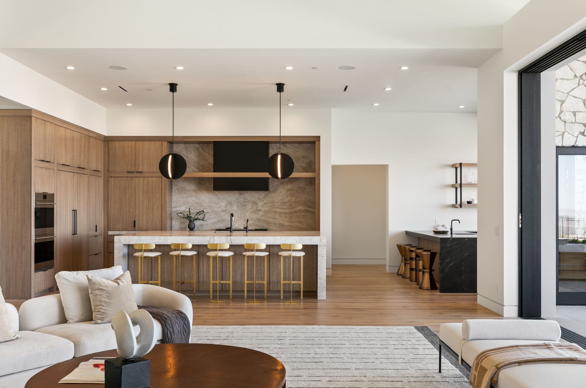 Modern luxury kitchen and open-concept living space in Ascaya with custom wood cabinetry and minimalist contemporary design