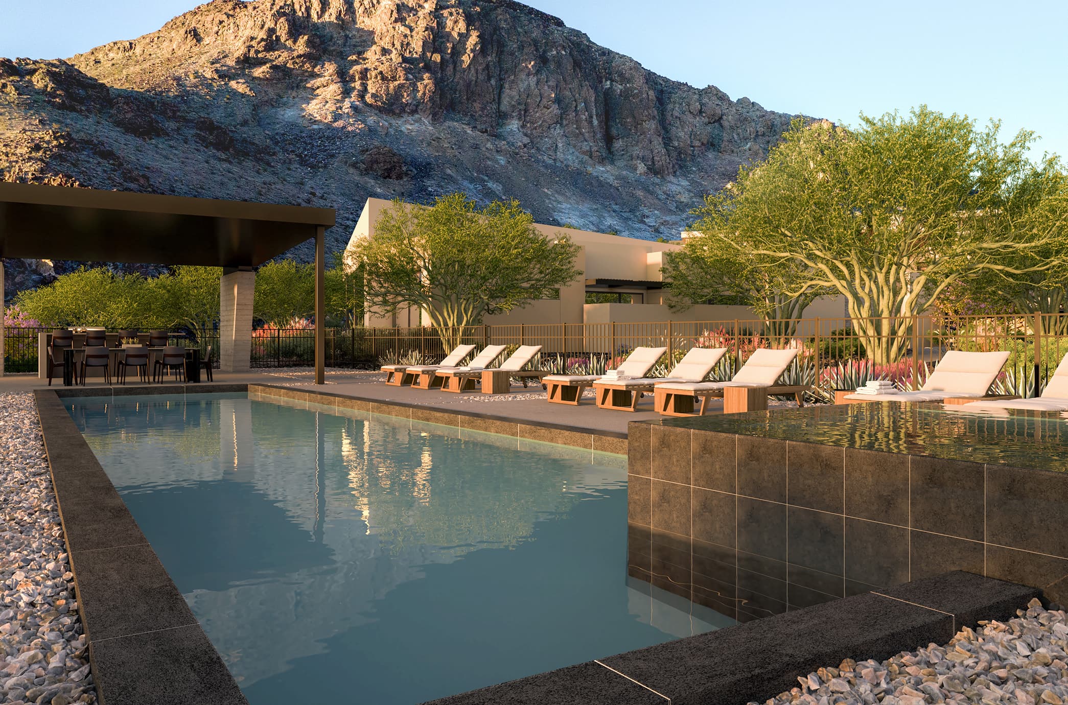 Luxury resort-style pool with lounge chairs, shaded dining area, and desert mountain backdrop.