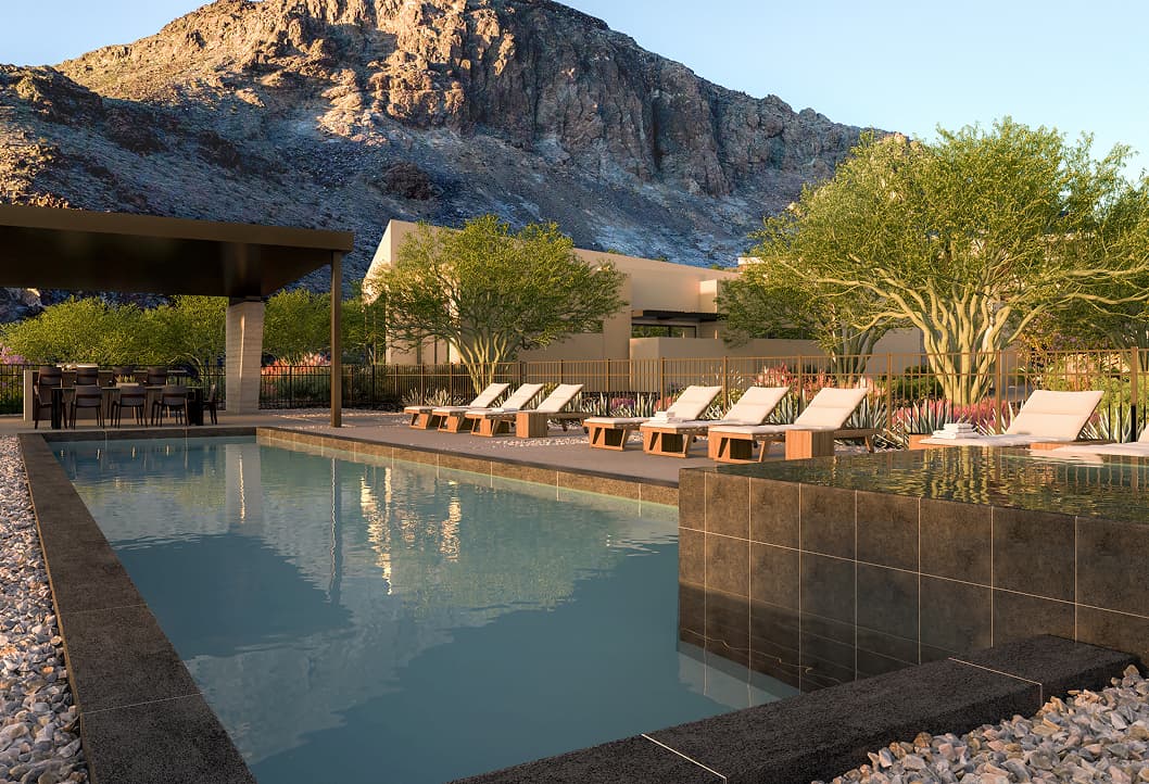 Luxury resort-style pool with lounge chairs, shaded dining area, and desert mountain backdrop.