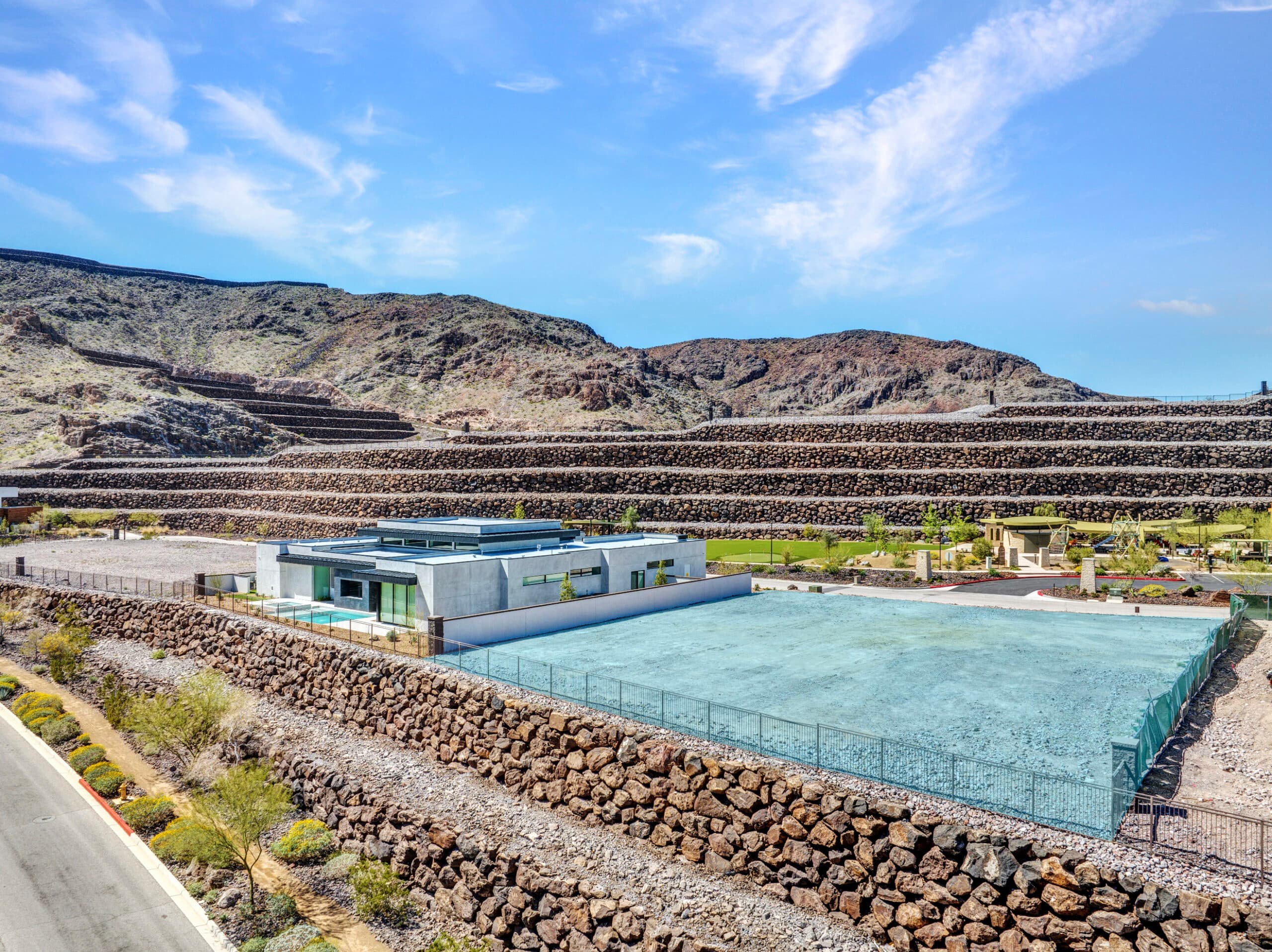 Aerial view of a modern hillside residential development in a desert landscape.