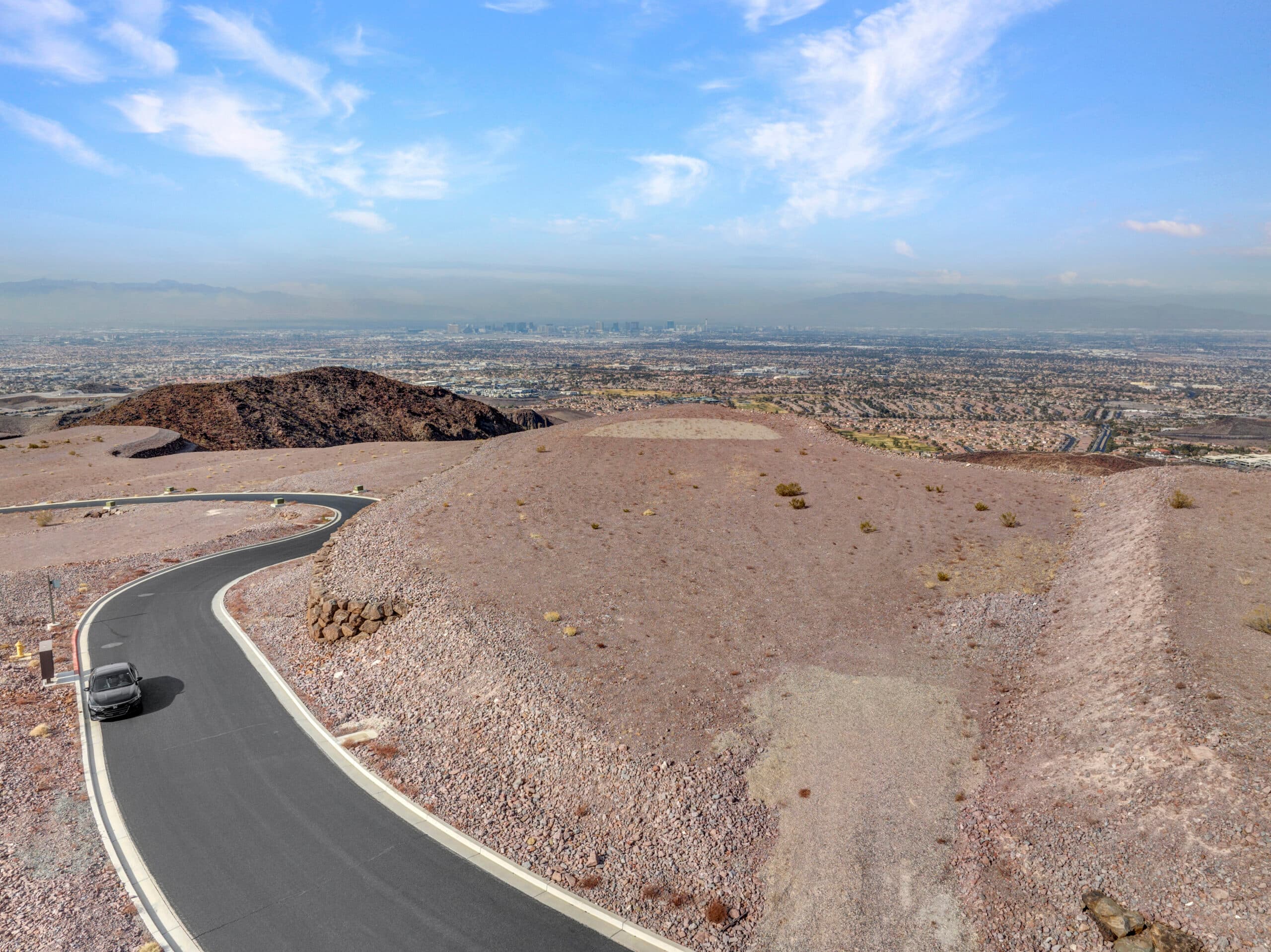 Expansive desert homesite with panoramic Las Vegas Strip and mountain views in luxury hillside community.