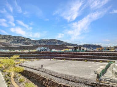 Aerial view of homesite lot outlined within a desert mountainside community development