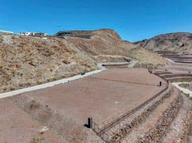 Aerial view of homesite lot outlined within a desert mountainside community development