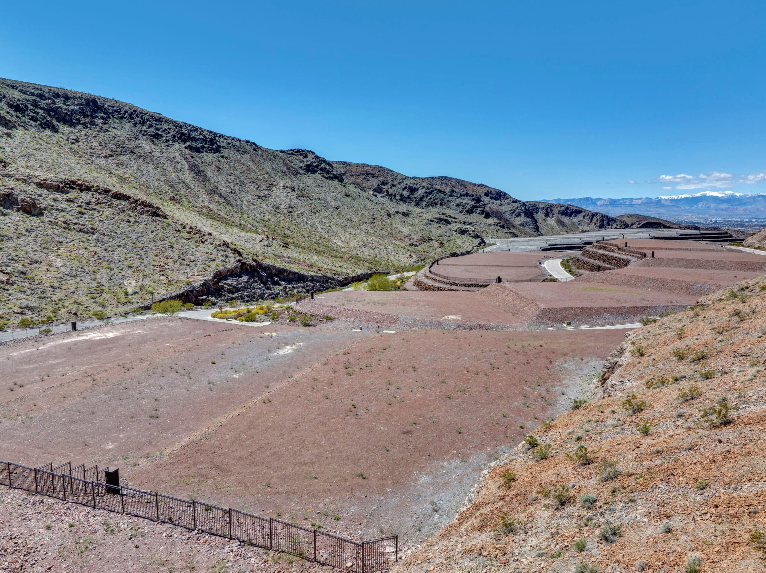 Sweeping desert canyon homesites with terraced lots and panoramic mountain views in an exclusive Las Vegas luxury community.