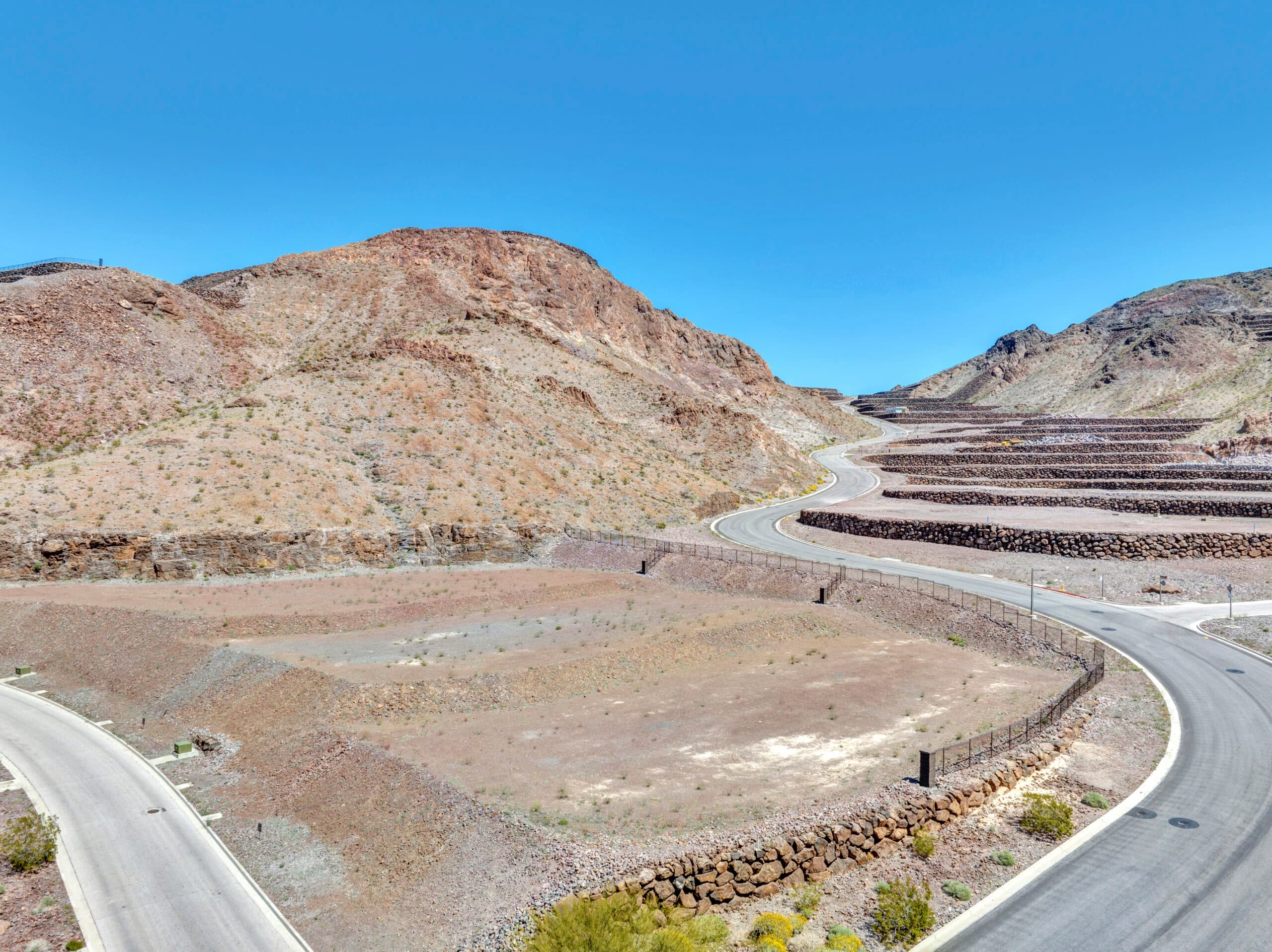 Sweeping desert canyon homesites with terraced lots and panoramic mountain views in an exclusive Las Vegas luxury community.