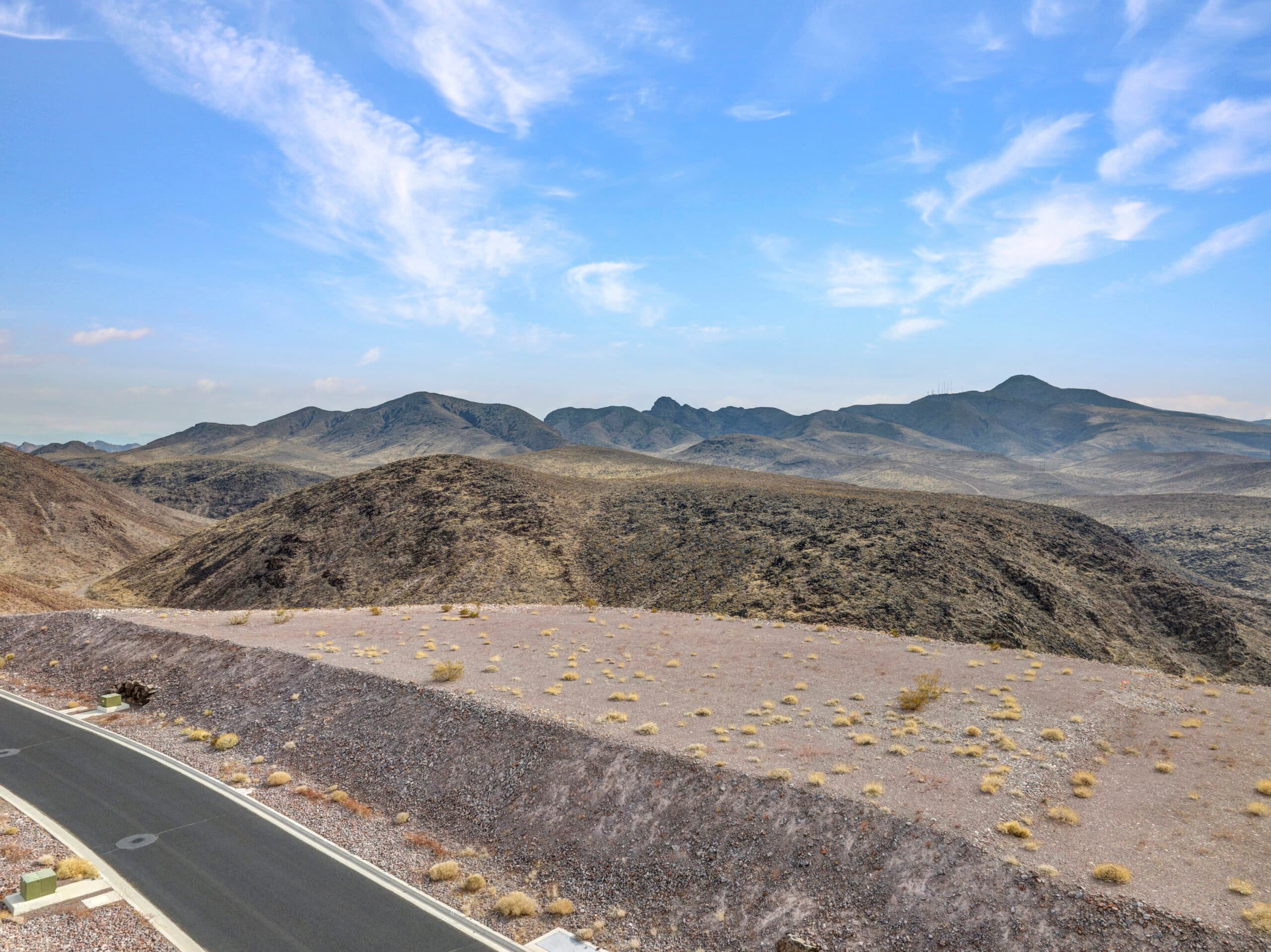 Elevated desert homesite with sweeping Las Vegas valley and mountain views in luxury hillside community.