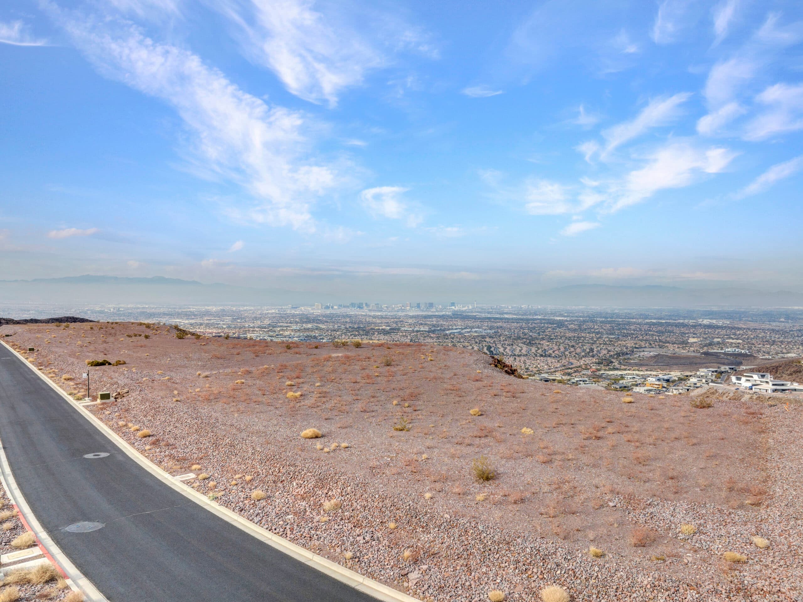 Expansive desert homesite with panoramic Las Vegas Strip and mountain views in luxury hillside community.