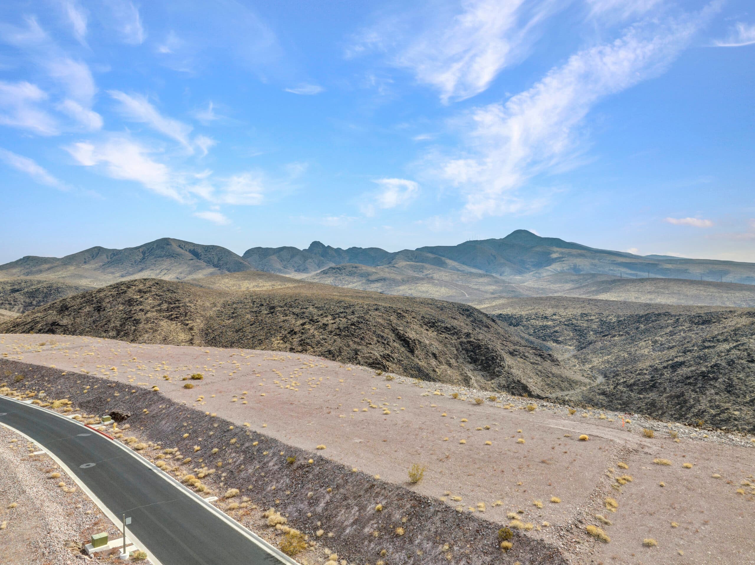 Elevated desert homesite with sweeping Las Vegas valley and mountain views in luxury hillside community.