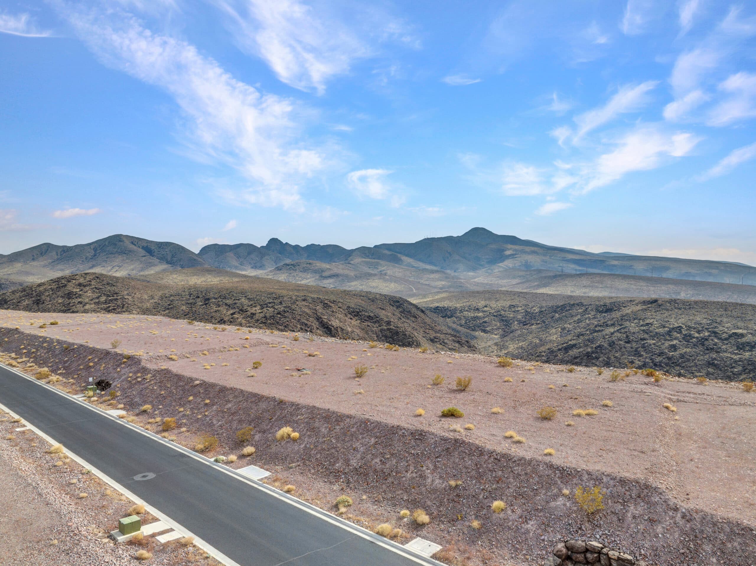 Elevated desert homesite with sweeping Las Vegas valley and mountain views in luxury hillside community.