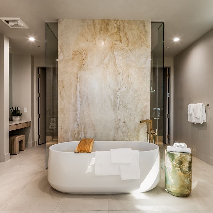 Spa-inspired luxury bathroom featuring a freestanding soaking tub, floor-to-ceiling stone accent wall, and refined contemporary finishes
