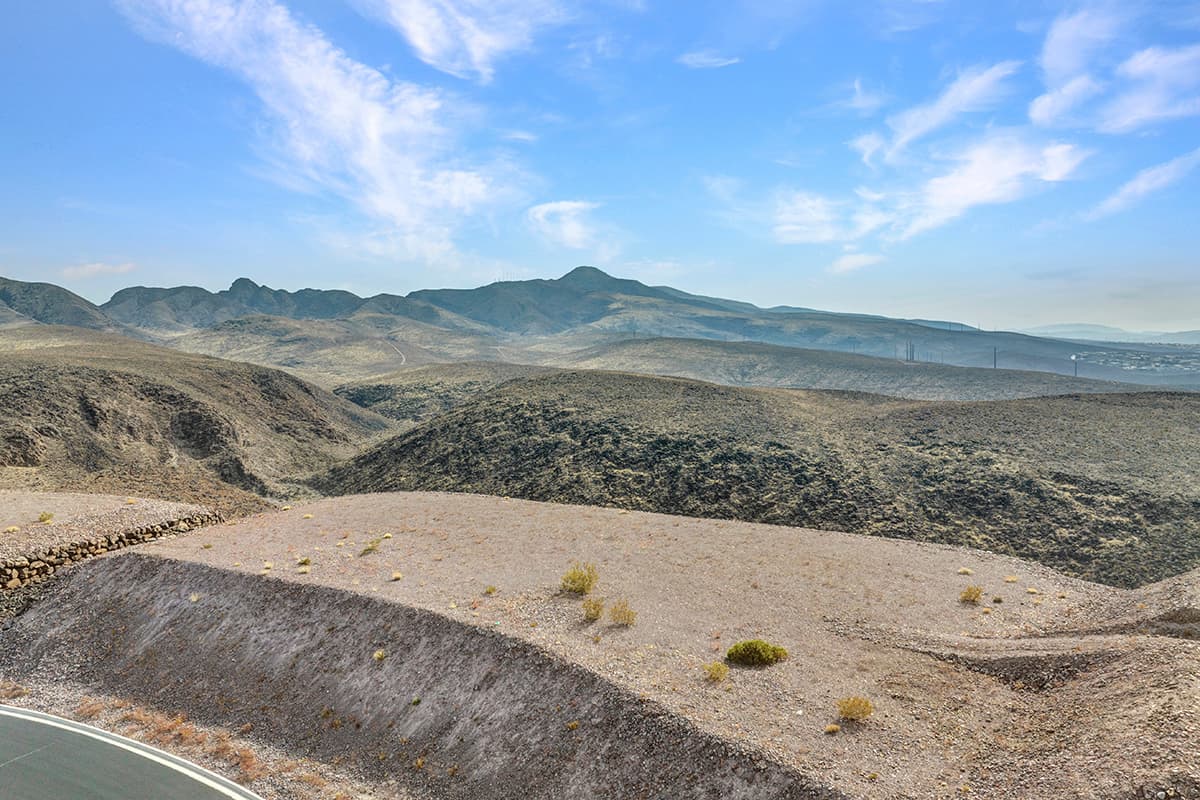 Elevated desert homesite with sweeping Las Vegas valley and mountain views in luxury hillside community.
