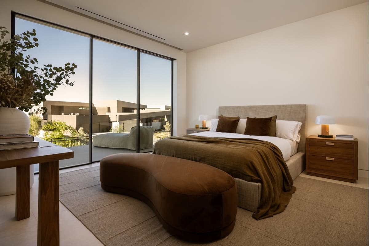 Modern luxury bedroom with floor-to-ceiling windows and a private terrace.