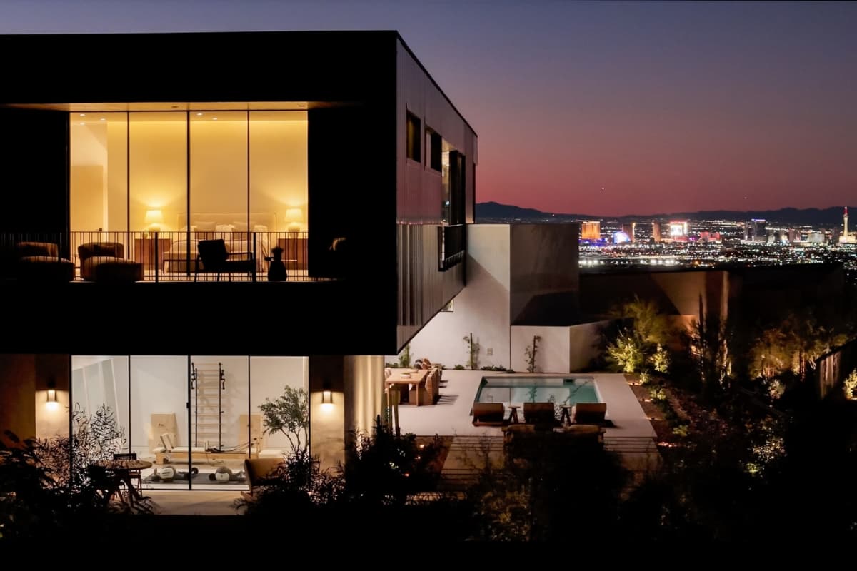 Modern luxury home with a private pool overlooking the Las Vegas skyline at night.
