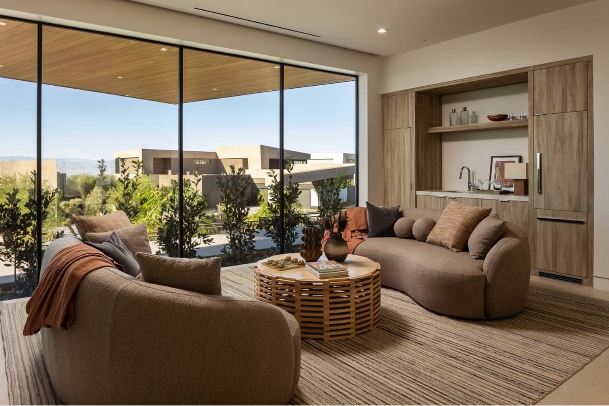 Modern luxury living room with floor-to-ceiling windows and panoramic desert views.