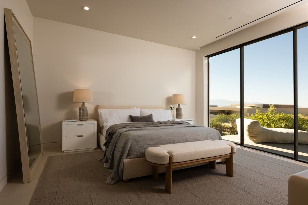 Modern luxury bedroom with floor-to-ceiling windows and panoramic desert views.