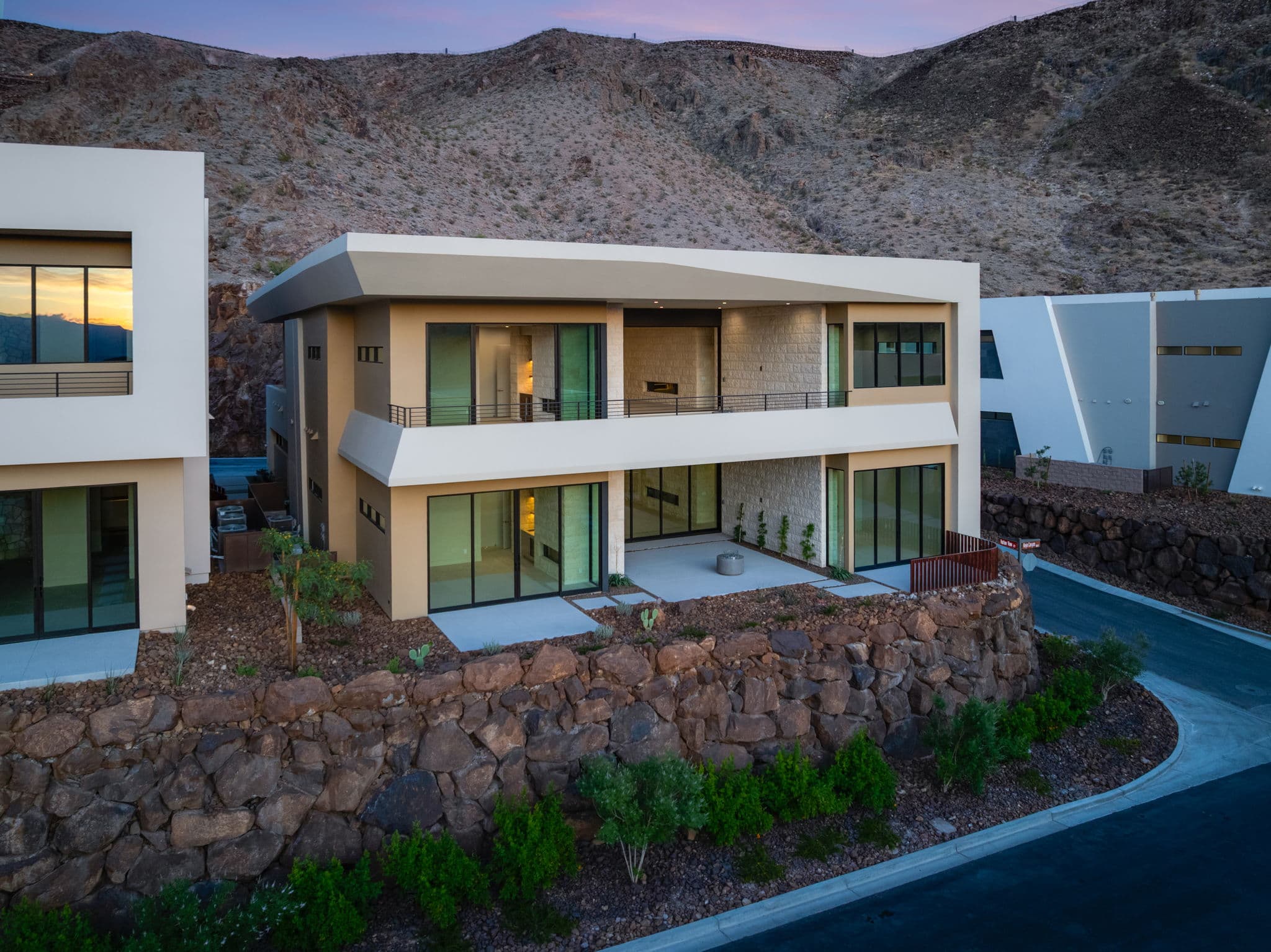 Modern two-story Canyon Residence with expansive balconies, floor-to-ceiling glass, and a private outdoor living area set against the desert mountainside