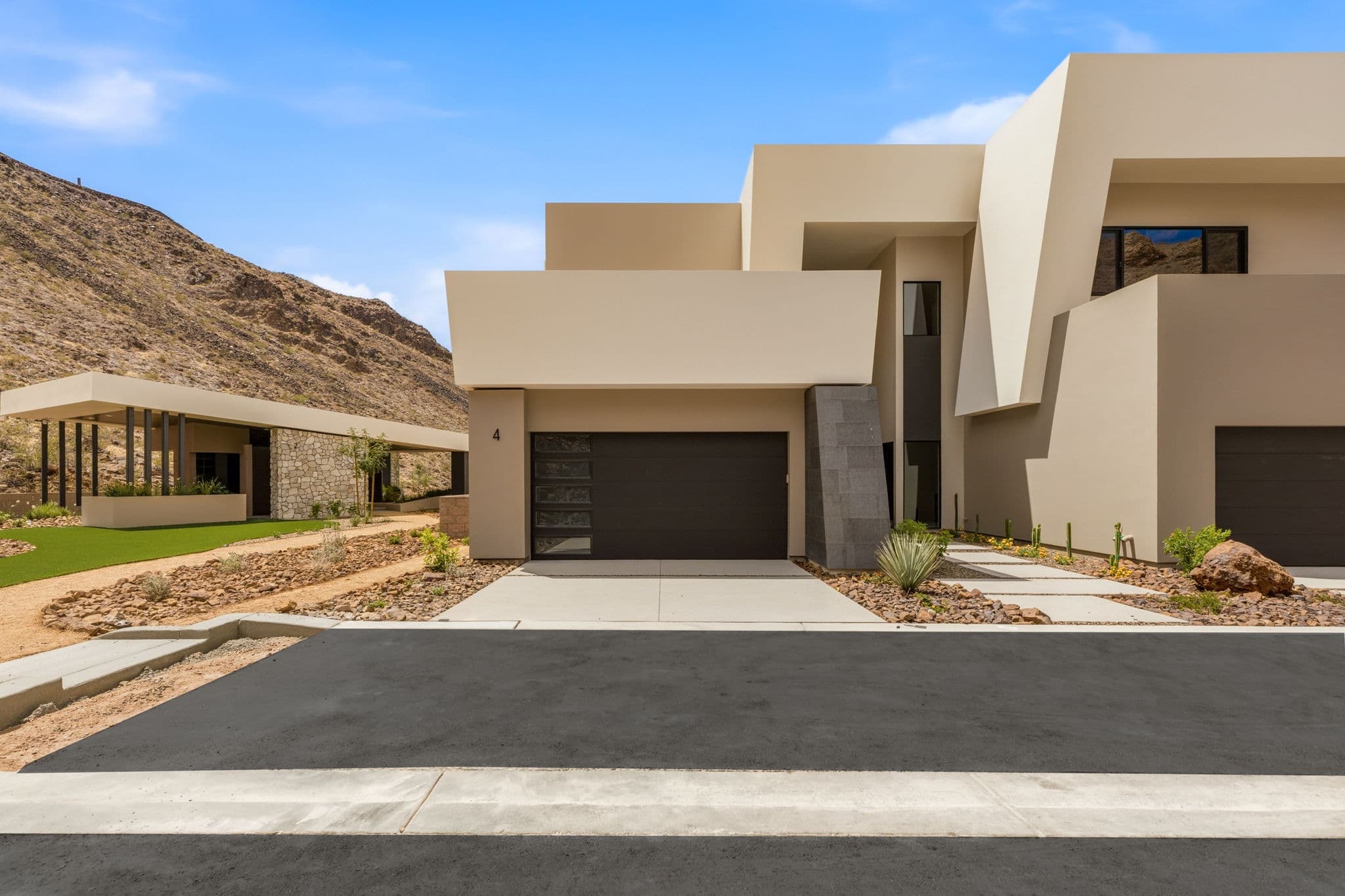 Modern desert residence with sculptural architecture, private driveway, and mountain surroundings within The Canyon Residences at Ascaya