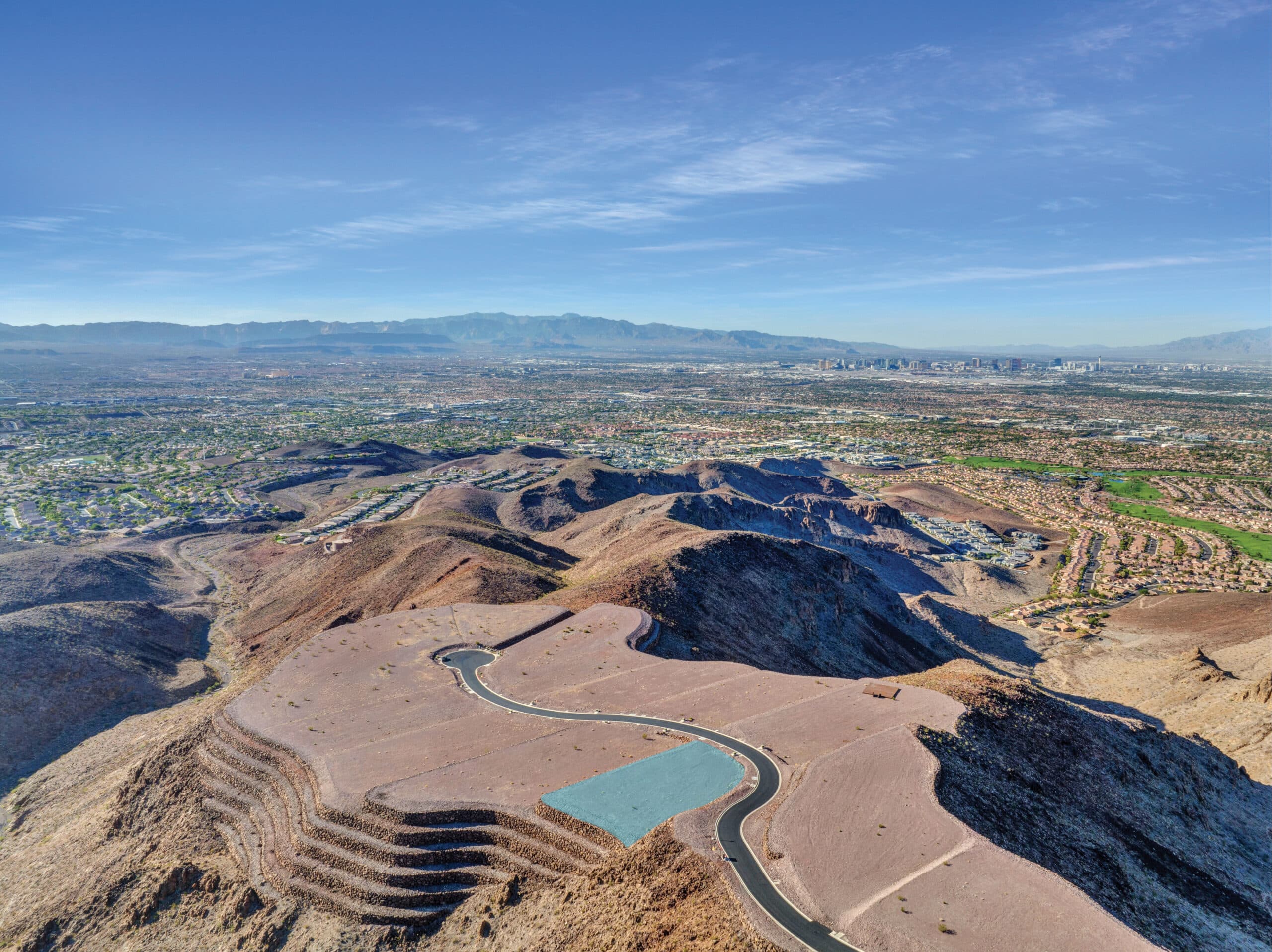 Aerial view of a modern hillside residential development in a desert landscape.