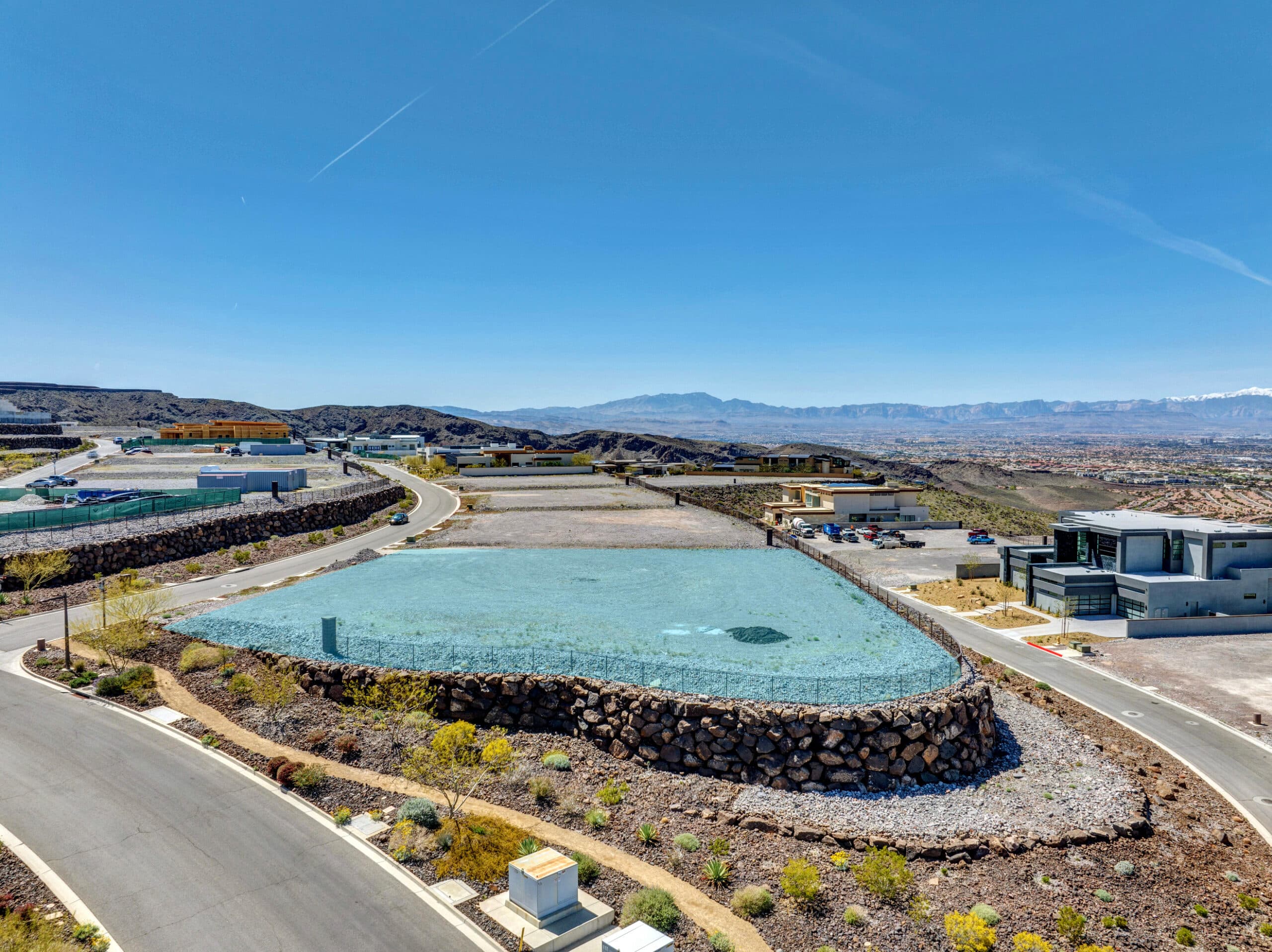 Aerial view of a modern hillside residential development in a desert landscape.